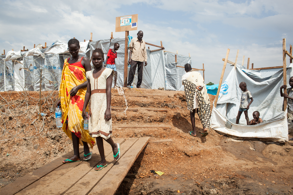 South Sudanese children walk around in a refugee camp